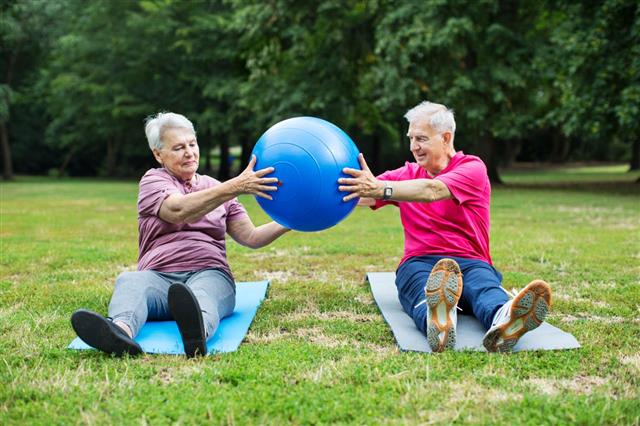 Senior Couple Exercising With Pilates Ball