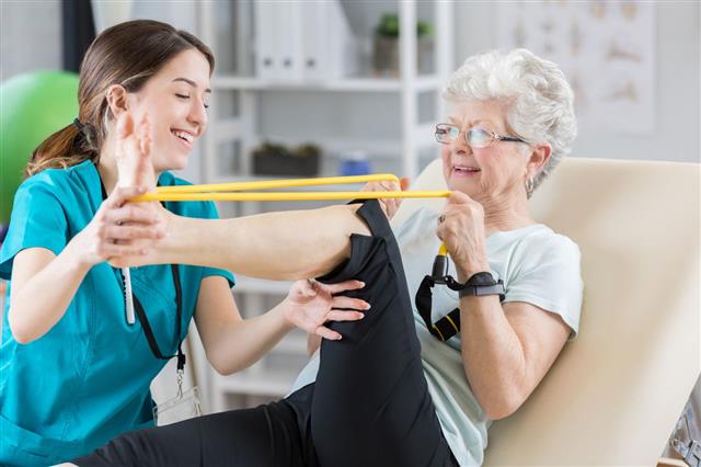 Physiotherapist Helps Patient Use Resistance Band