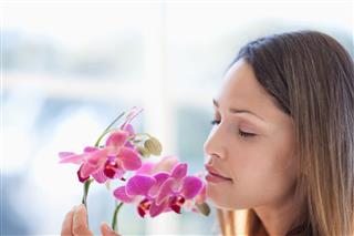 Woman With Eyes Closed Smelling Orchid
