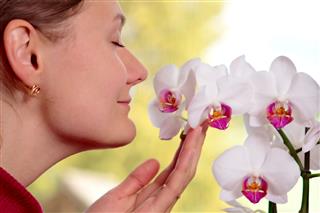 Woman Smelling The Orchid