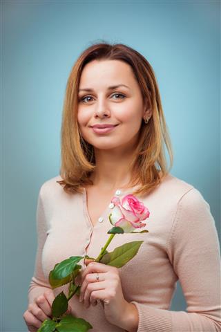 Woman Holding Rose And Smiling
