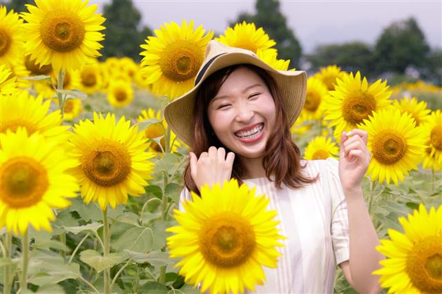 Young Female Smiling In Sunflower Field