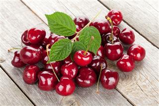 Ripe Cherries On Wooden Table