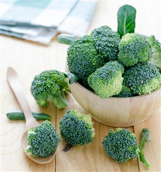 Broccoli on wood table with spoon