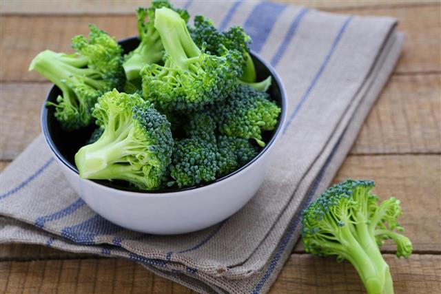 Fresh broccoli in a bowl on rustic table