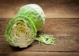 Cabbage and cut cabbage on wooden