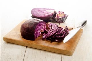 Red cabbage prepared and sliced on a wooden board