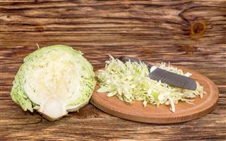 Sliced cabbage with knife on a board
