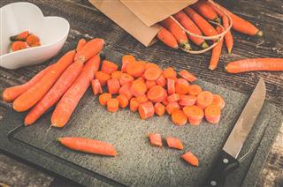 Chopping carrots on a rustic old vintage oak kitchen table