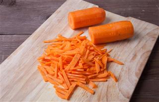 Sliced carrots on a wooden cutting board