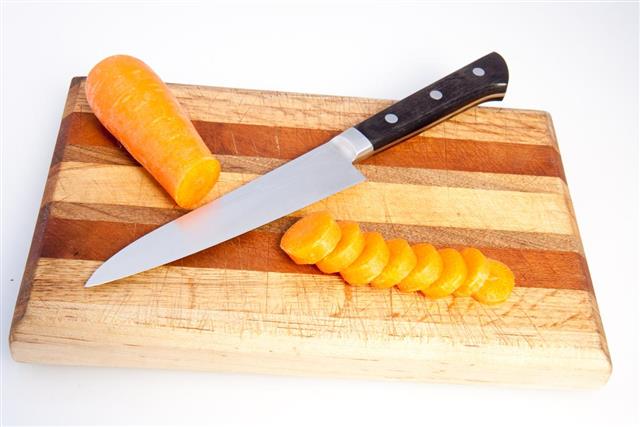 Knife on cutting board with carrot