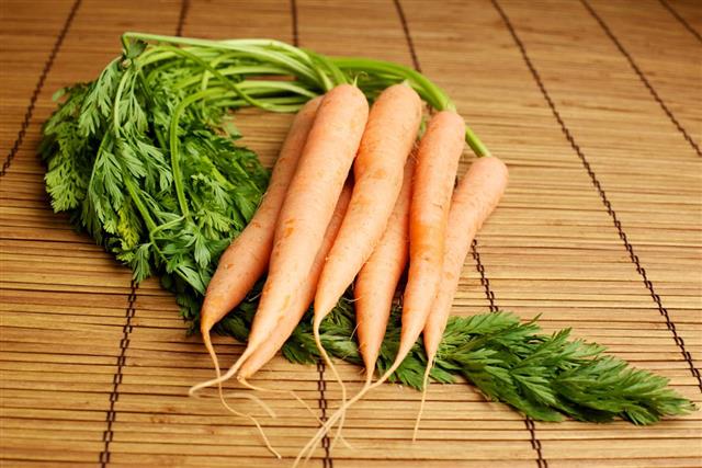 Organic carrots on bamboo background