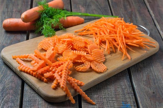 Sliced carrots and parsley on a cutting board