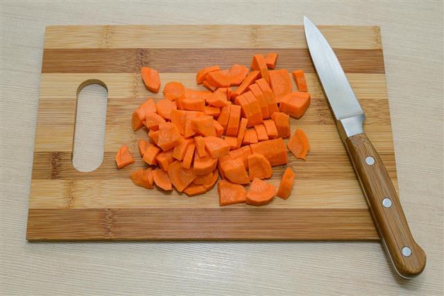 Sliced carrots and a knife on a cutting board