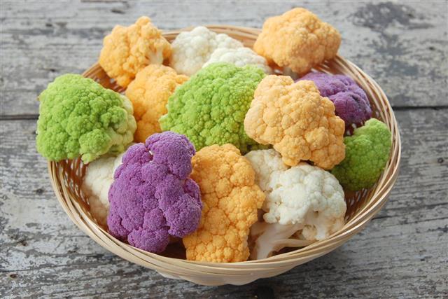 Purple, green, yellow and white cauliflower in a bowl