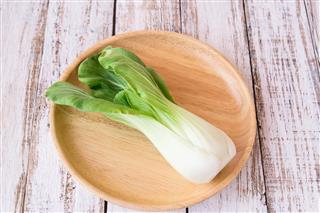 Fresh leaves of romaine lettuce in a rustic wooden plate