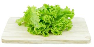 Salad leaf. Lettuce isolated on wooden cutting board