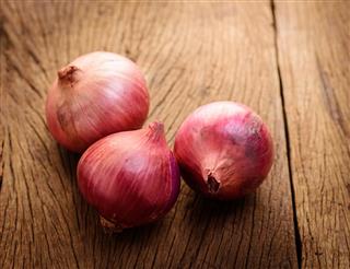 Red onions on a wooden background