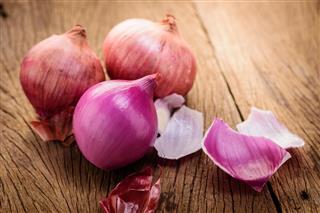 Red onions on a wooden background