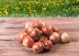 Small pile of onions on a wooden background