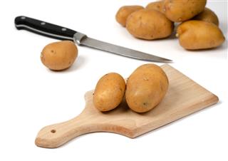 Potatoes On A Wooden Chopping Board