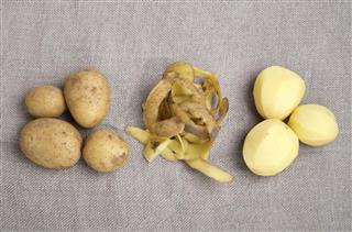 Raw potatoes and peels on burlap