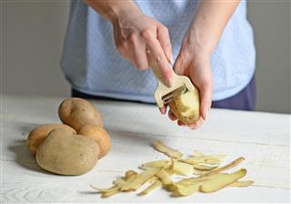 Woman hands peeling potato
