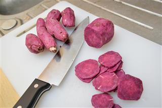 Slices of Japanese purple sweet potato on the cutting board