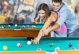 Man Teaching His Girlfriend To Play Pool