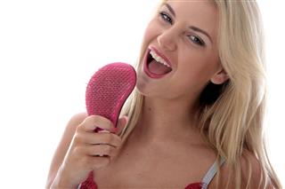 Young Woman Singing Into A Hairbrush