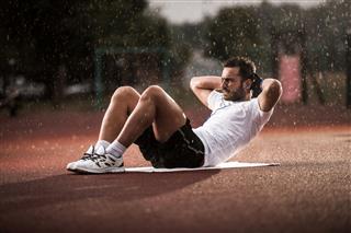 Young Man Exercising In Rain