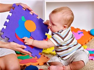 Baby Playing Jigsaw Puzzle With Mother
