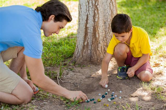 Boy Playing Marbles With Dad