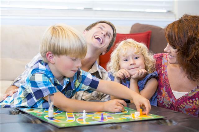 Family With Kids Playing Board Game