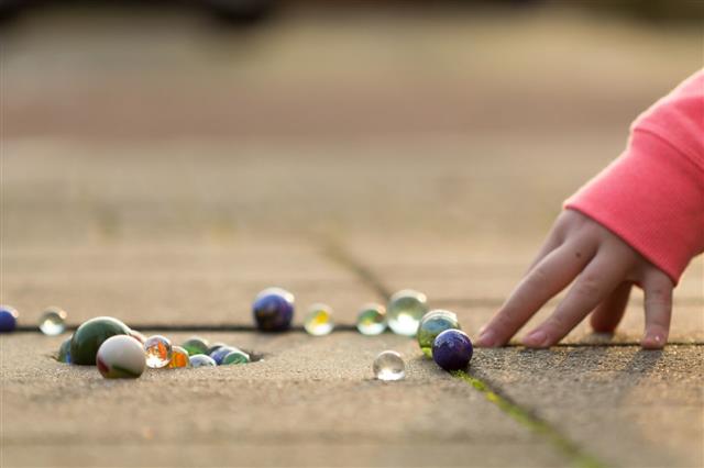 Child Playing With Marbles