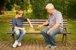 Grandfather And Grandson Playing Chess