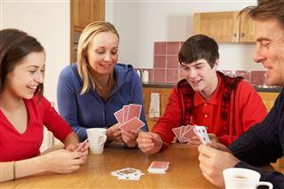 Family Playing Cards In Kitchen