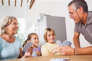 Children Playing Cards With Grandparents