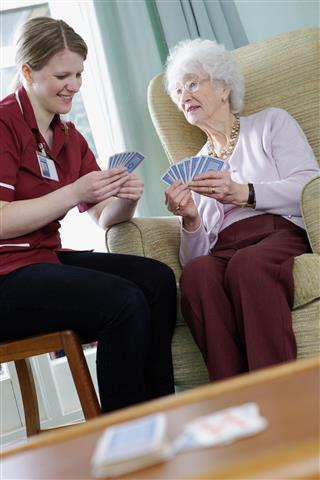 Nurse Playing Cards With Senior Woman