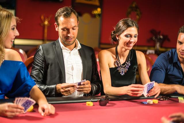 Friends Playing At Poker At Casino