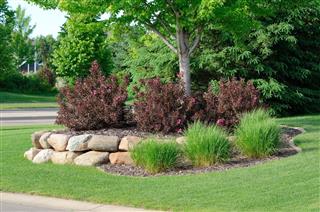 Landscaping With Weigela Shrubs And Rock Retaining Wall
