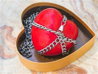 Red heart tied with chains
