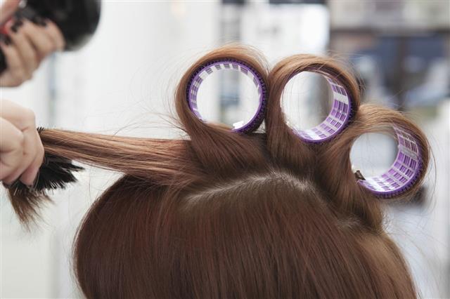 Hairdresser Rolling Up Curlers For Client