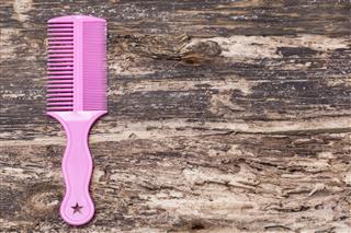 Pink Comb On Wood Background
