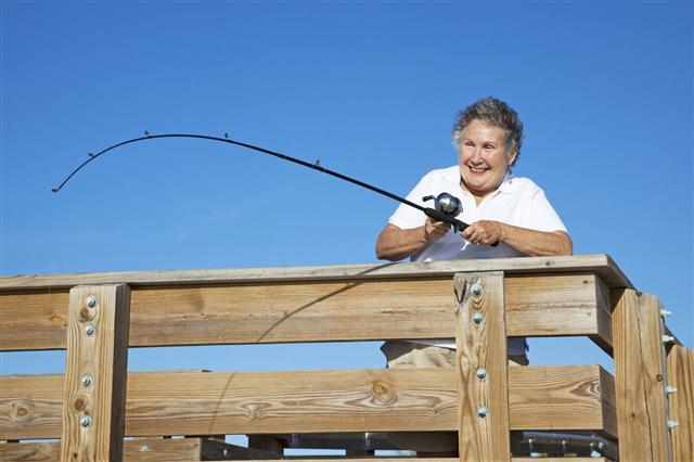 Senior Lady Reels In Fish