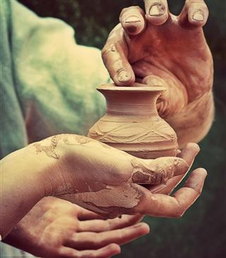 Hand Holding Pottery Jar