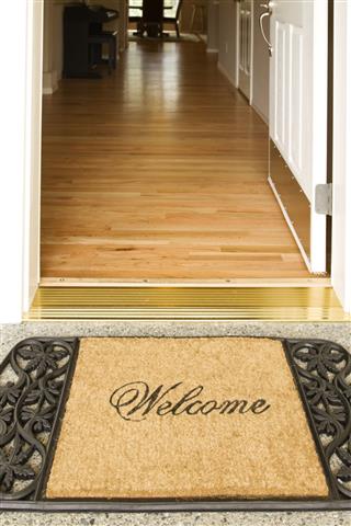 Welcome Home Mat Placed Outside Of An Open Door