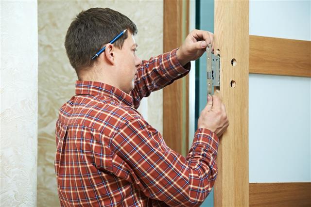 Carpenter At Door Lock Installation