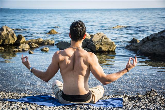 Young Man Meditating Or Doing Yoga