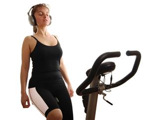Woman Listening Music On Spinning Bicycle